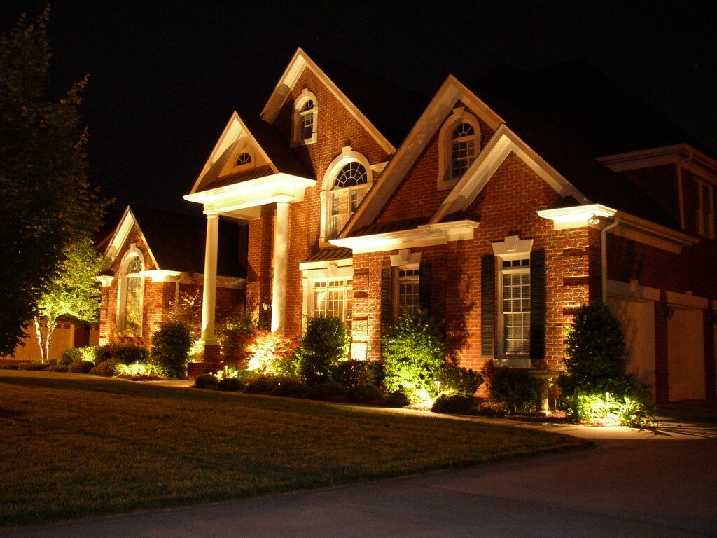 Brick home at night with full facade up-lighting and accent fixtures