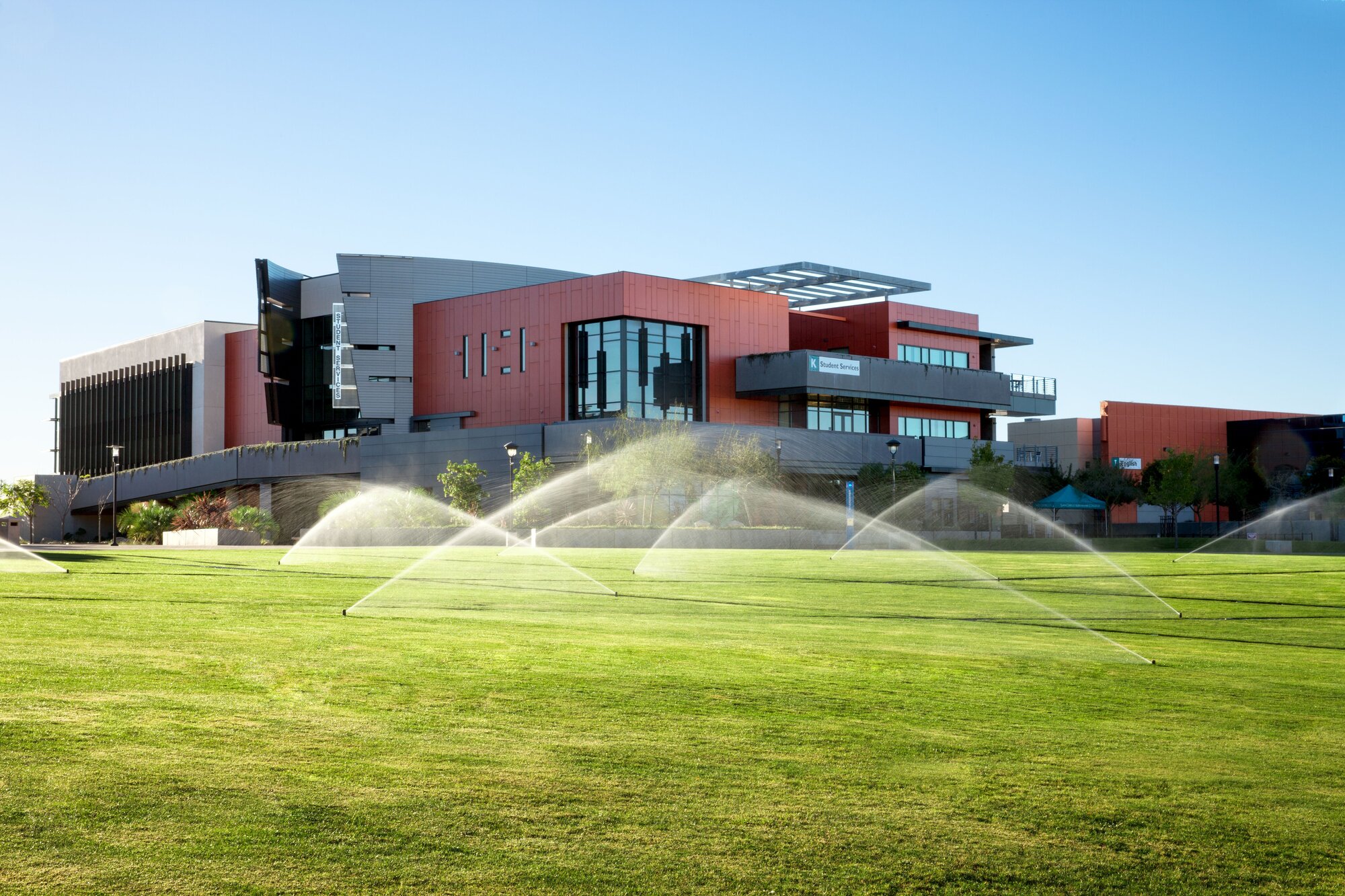 Commercial sprinkler install — multiple rotors running across an institutional lawn